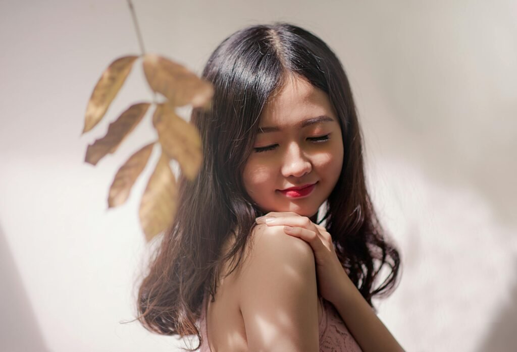 Peaceful young woman with eyes closed, embracing serenity with a gentle smile.
